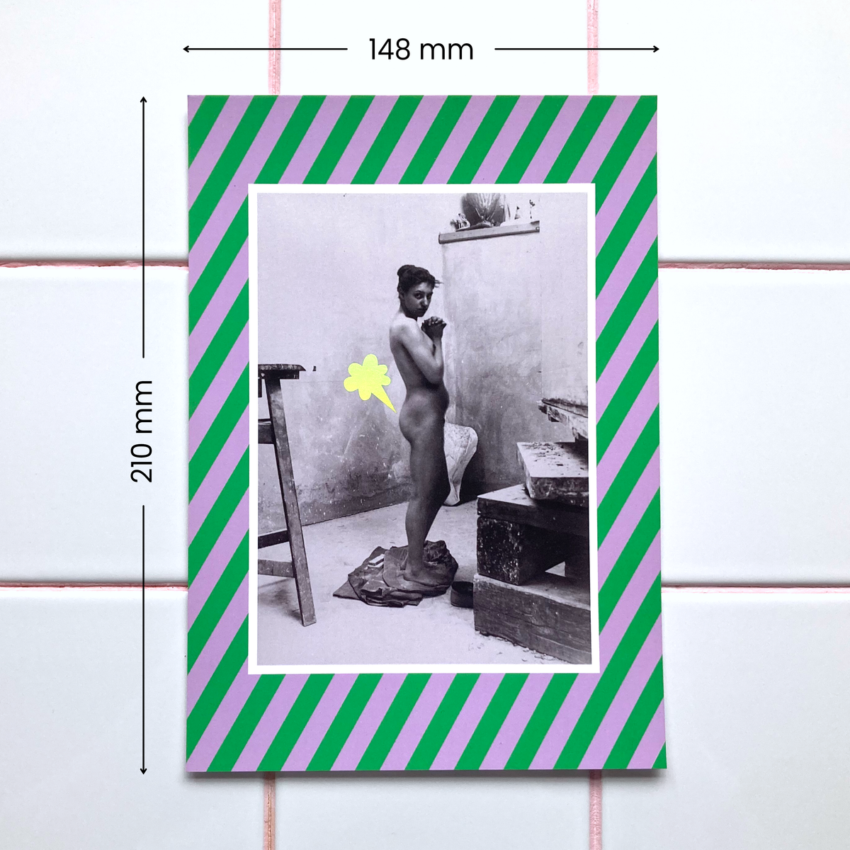 A 148x210mm poster featuring a photograph of a nude female standing in an art studio framed by a green and lilac striped border. A playful cartoon-style fart cloud, printed in holographic foil, is placed next to her bum.