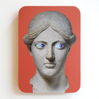 A printed statue head on a red rectangular background with blue eyes and purple pupils that both look to the right.